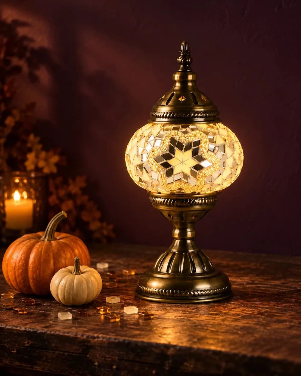 A glowing Turkish mosaic lamp among pumpkins